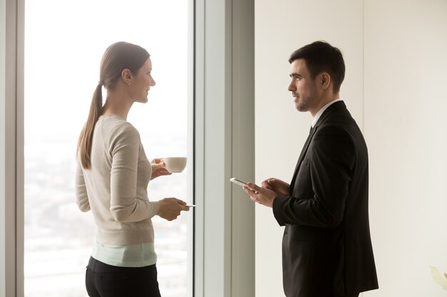 Lächelnde Geschäftsteammitglieder, die im Büro sprechen