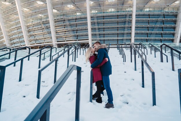 Lächelnde glückliche europäische Paare der Junge, die im Winter umarmen