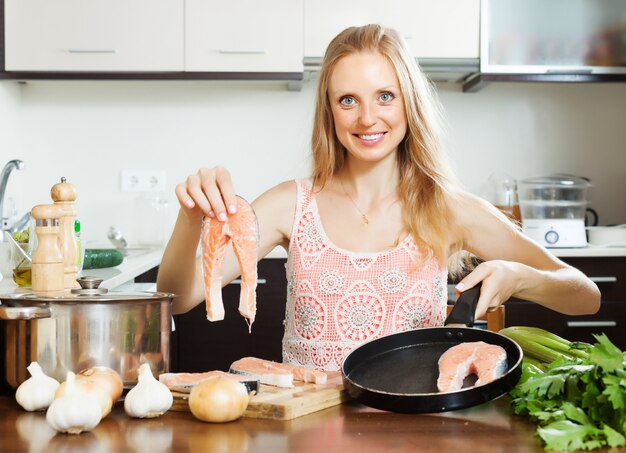 Kostenloses Foto lächelnde hausfrau kocht lachs