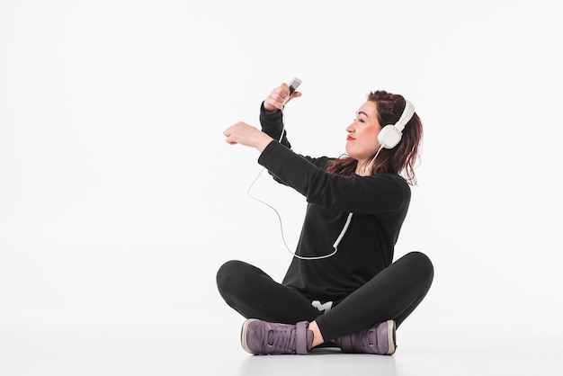 Lächelnde hörende Musik der jungen Frau auf MP3-Player