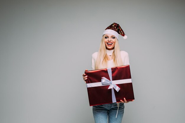 Lächelnde hübsche Dame mit roter Geschenkbox mit Geschenkbandschleife