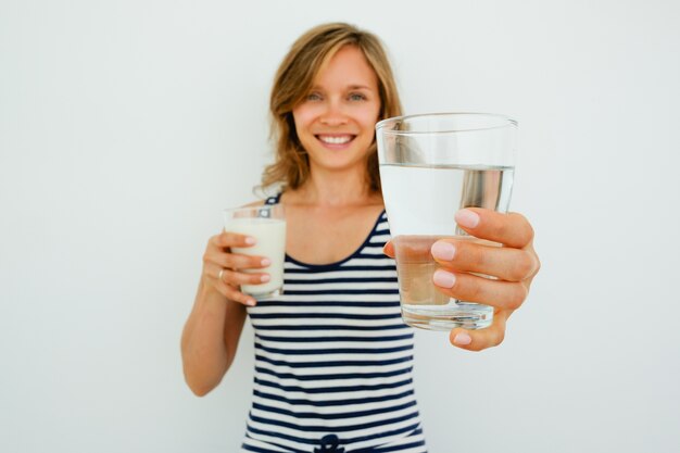 Lächelnde Hübsche Frau, die Glas Wasser anbietet