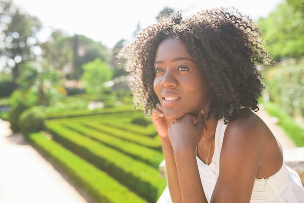 Lächelnde hübsche schwarze Frau, die im Park sich entspannt