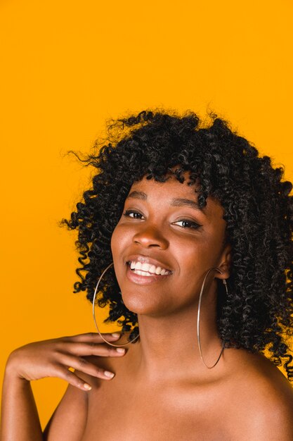 Lächelnde junge Afroamerikanerfrau auf farbigem Hintergrund