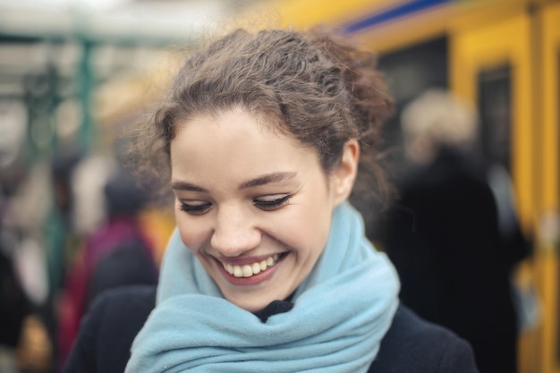 Lächelnde junge Frau außerhalb eines Bahnhofs