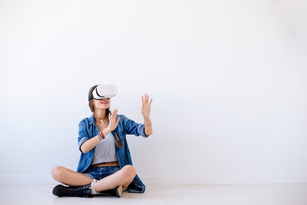 Lächelnde junge Frau benutzen VR-Gläser