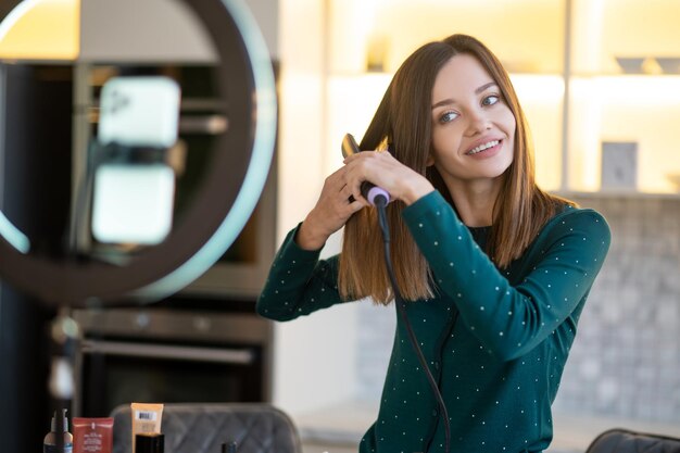 Lächelnde junge Frau, die Tipps zur Haarpflege zeigt