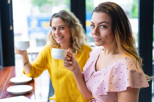 Lächelnde junge Frauen, die Kaffee im Café trinken