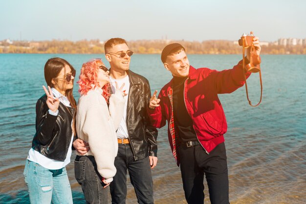 Lächelnde junge Freunde, die Gesichter beim Nehmen von selfie machen