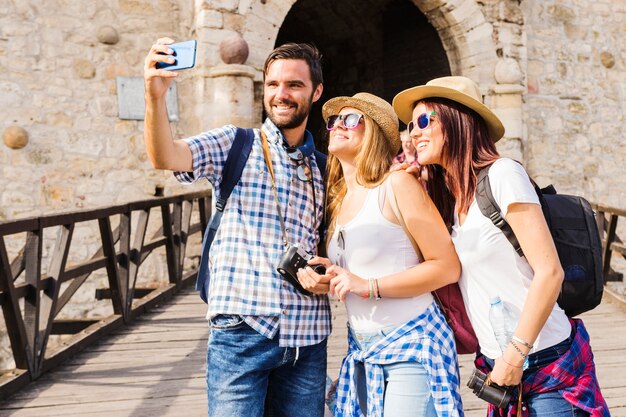 Lächelnde junge Freunde, die selfie auf Mobiltelefon nehmen