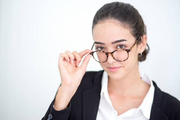 Lächelnde junge Geschäftsfrau berühren Brille