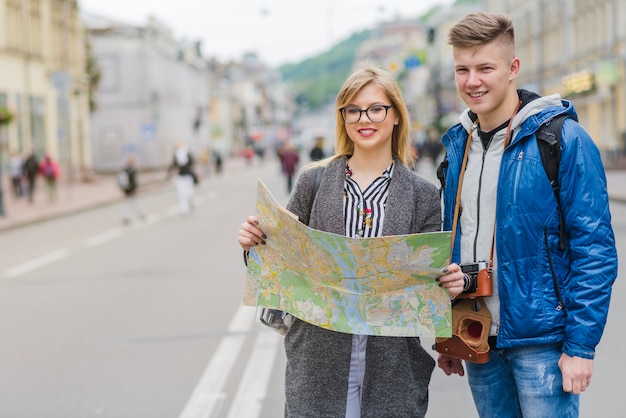 Lächelnde junge Paar mit Karte