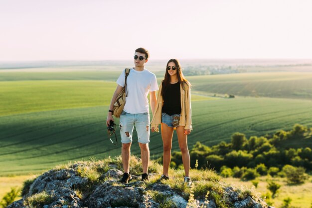 Lächelnde junge Paare, die auf Felsen stehen