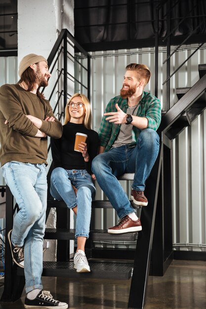 Lächelnde Kollegen im Büro sprechen miteinander