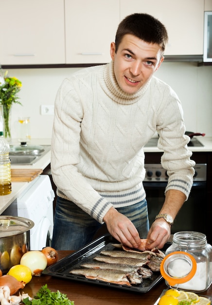 Kostenloses Foto lächelnde männer, die forellenfische kochen