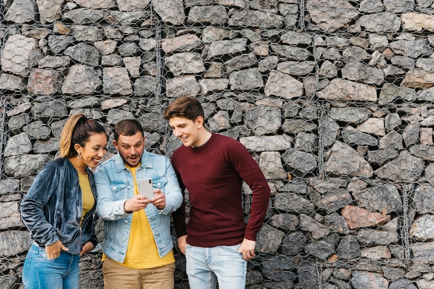 Lächelnde multiethnische Freunde, die selfie am Telefon nehmen