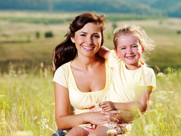 Lächelnde Mutter und kleine Tochter über die Natur.