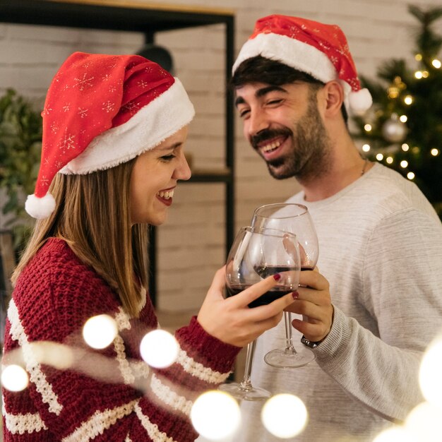 Lächelnde Paare, die am Weihnachtsabendessen rösten