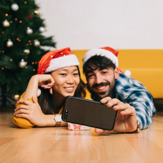 Lächelnde Paare, die selfie am Weihnachten nehmen