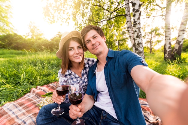 Lächelnde Paare, die selfie auf Picknick nehmen