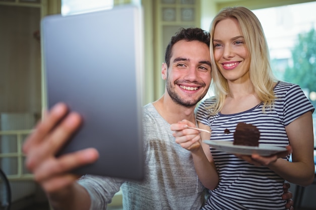 Lächelnde Paare, die selfie von digitalen Tablet