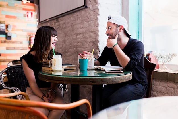 Lächelnde Paare, die zusammen im Café sitzen