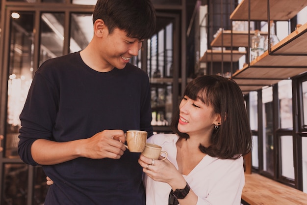 Lächelnde Paare mit Tassen Kaffee röstet