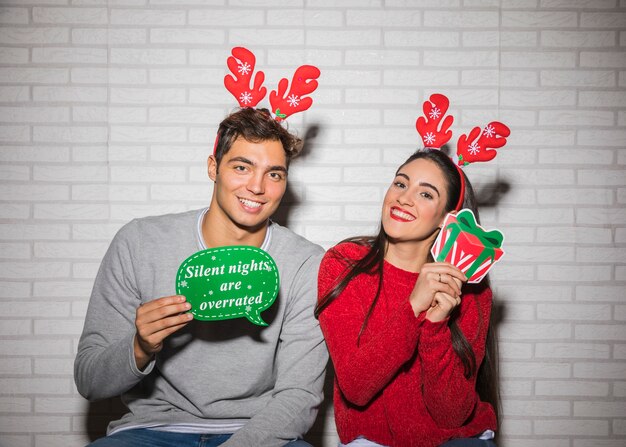 Lächelnde Paare mit Weihnachtsdekorationen