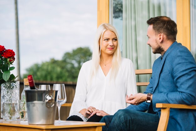 Lächelnde reizende Paare, die einander im Restaurant betrachten