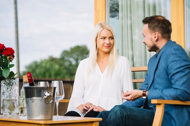 Lächelnde reizende Paare, die einander im Restaurant betrachten