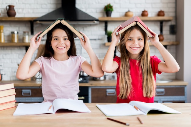 Lächelnde Schulmädchen unter Buchdach