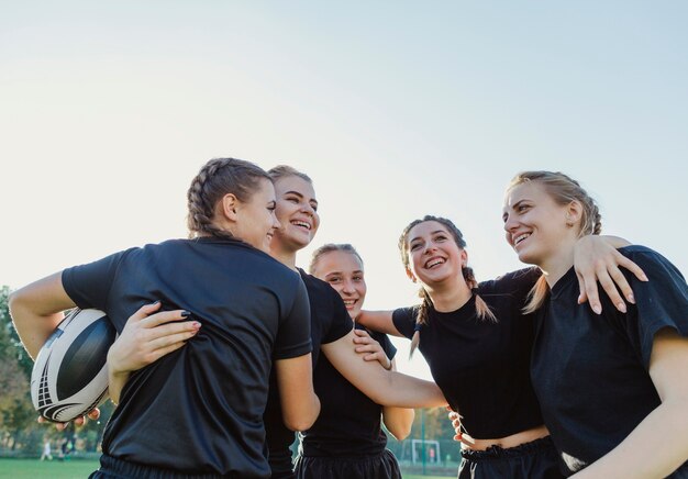 Lächelnde sportive Frauen, die sich umfassen