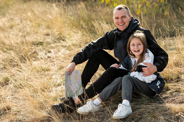 Lächelnde Tochter und Vater, die Fotografen betrachten