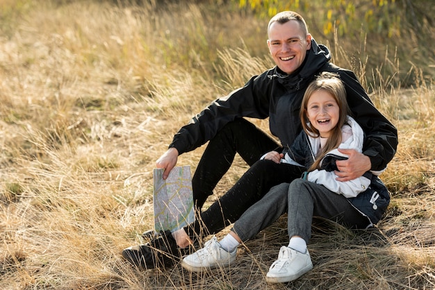 Lächelnde Tochter und Vater, die Fotografen betrachten