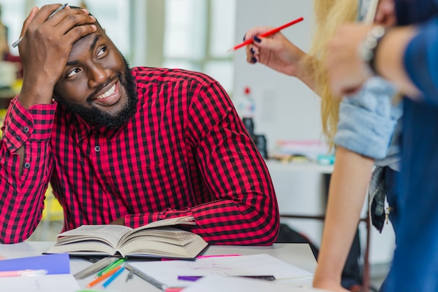 Lächelnde verschiedene Studenten am Desktop