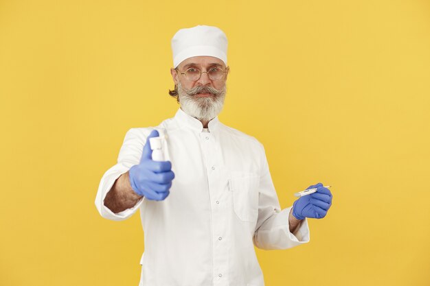 Lächelnder Arzt mit Thermometer. Isoliert. Mann in blauen Handschuhen.