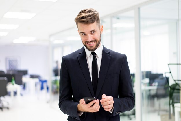 Lächelnder eleganter Mann mit einem Smartphone