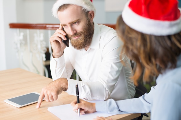 Lächelnder erfolgreicher Geschäftsmann, der frohe Weihnachten wünscht