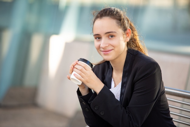 Lächelnder erfolgreicher weiblicher Manager, der Kaffeepause genießt