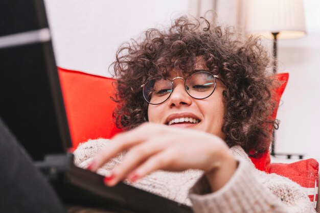 Lächelnder Jugendlicher, der Laptop durchstöbert