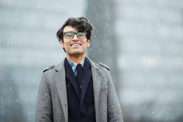 Lächelnder junger Geschäftsmann im Schnee