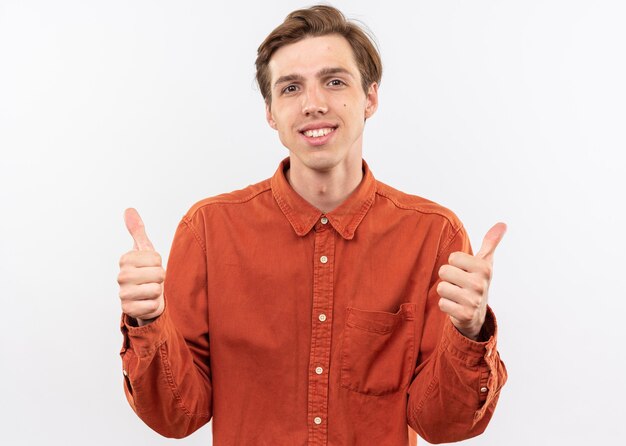 lächelnder junger gutaussehender Kerl, der rotes Hemd trägt und Daumen nach oben zeigt, isoliert auf weißer Wand