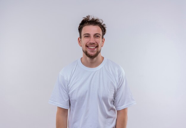 Lächelnder junger Mann, der weißes T-Shirt auf lokalisiertem weißem Hintergrund trägt
