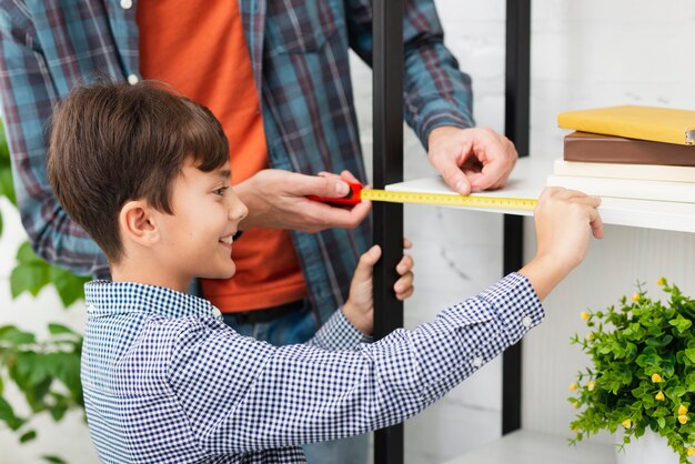 Lächelnder kleiner Junge, der ein Selbst misst