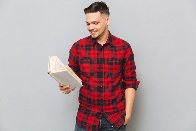 Lächelnder Mann, der Buch im Studio liest