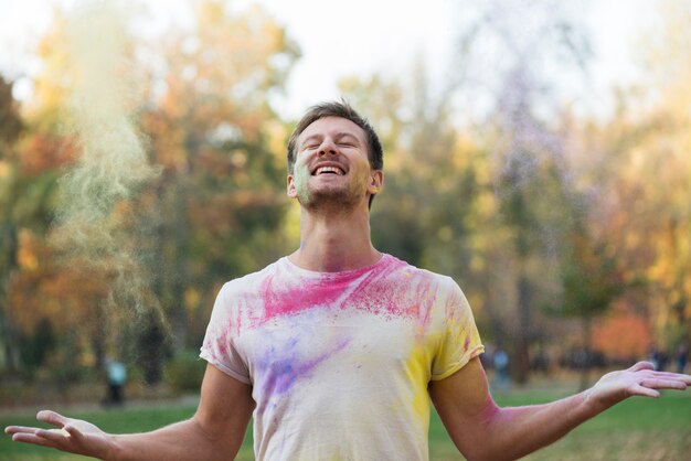 Lächelnder Mann, der holi Festival genießt