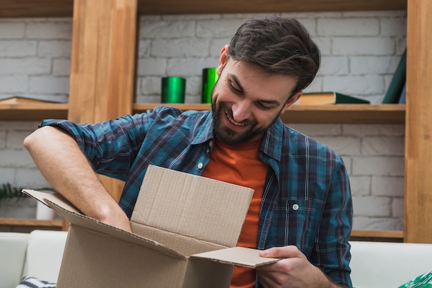 Lächelnder Mann, der Paket kontrolliert