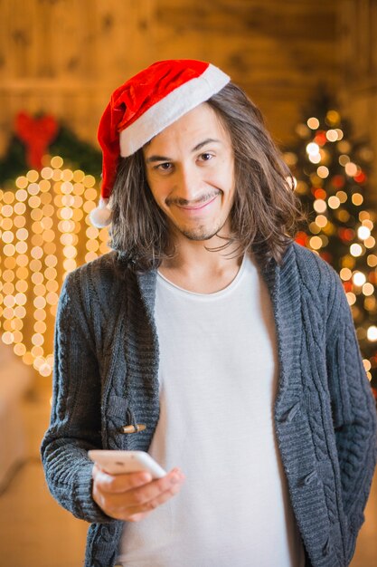 Lächelnder Mann mit Smartphone am Weihnachten