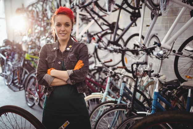 Lächelnder Mechaniker stehend mit gekreuzten Armen