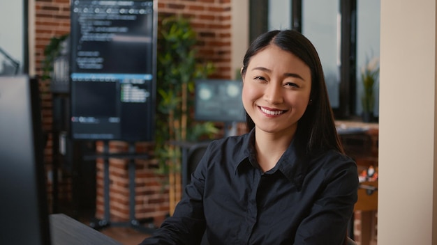 Lächelnder Softwareentwickler tippt App-Code für maschinelles Lernen auf der Computertastatur am Schreibtisch im Big-Data-Büro ein. Freundlicher Cloud-Programmierer, der gelegentlich in einer Cybersicherheitsagentur arbeitet.